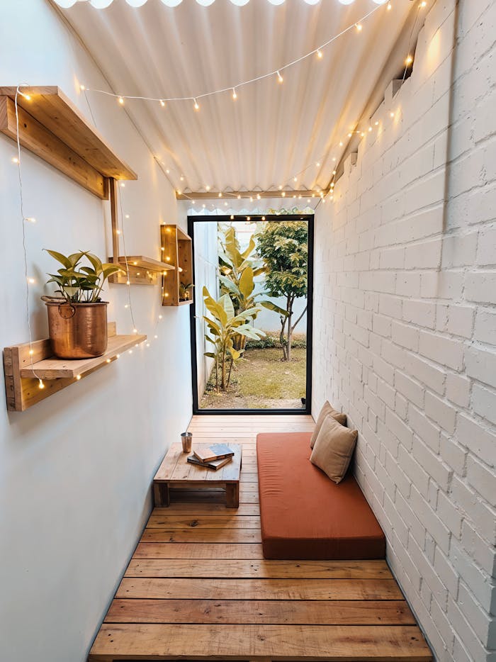 Charming indoor nook with lights, plants, and a comfy cushion for relaxing.
